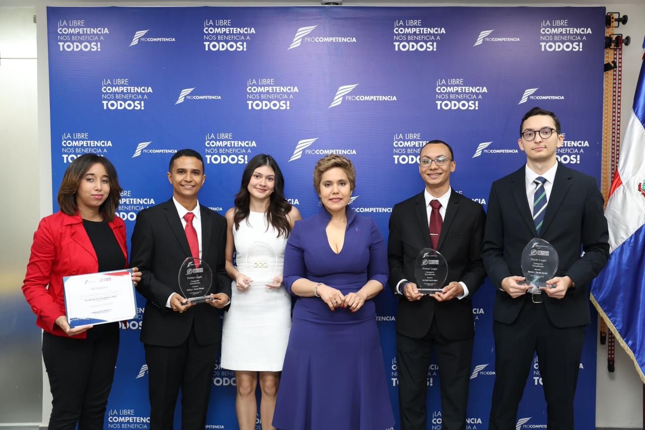 *ProCompetencia premia a estudiantes y profesionales en su concurso nacional de ensayos* _Durante la entrega de premios, la presidenta del Consejo Directivo de ProCompetencia anunció que la institución publicará un libro con todos los ensayos ganadores de las ediciones realizadas hasta la fecha._ Santo Domingo, D.N. – La Comisión Nacional de Defensa de la Competencia (ProCompetencia) entregó este viernes los premios a los ganadores de la tercera edición del concurso de ensayos “Escribiendo X la Competencia”, una iniciativa que este año alcanzó cifras récord de participación y consolidó su rol como plataforma para el análisis y la reflexión sobre los mercados y la libre competencia en el país. La presidenta del Consejo Directivo de ProCompetencia, María Elena Vásquez Taveras, destacó que en esta edición se incorporó por primera vez la participación de profesionales, lo que amplió la diversidad y profundidad de los trabajos recibidos. Vásquez Taveras subrayó que este año se recibieron más de 50 ensayos, lo que evidencia el creciente interés por estos temas y la consolidación del concurso como un espacio que enriquece el debate nacional sobre la competencia. Asimismo, resaltó que iniciativas como el concurso de ensayos “Escribiendo X la Competencia” contribuyen a reconocer el papel fundamental que juega la competencia como motor del desarrollo económico y la creación de mercados dinámicos, eficientes y abiertos. En ese sentido, citó una publicación reciente del Banco Interamericano de Desarrollo (BID), que señala que una mayor competencia podría incrementar el PIB en más de un 11 % en América Latina y el Caribe. Vásquez Taveras valoró la calidad de los ensayos recibidos en esta edición, destacando que se abordaron temas de vanguardia y de alta pertinencia nacional. Enfatizó que los trabajos ganadores trataron asuntos clave para el presente y futuro de la competencia en el país, como la colusión algorítmica, la inteligencia artificial aplicada a las compras públicas, la regulación de mercados digitales y la competencia en sectores regulados como energía y agua potable, entre otros. Finalmente, resaltó que esta iniciativa representa “una inversión en capital humano”, orientada a fortalecer el pensamiento crítico y la creación de capacidades técnicas en el país. “Cada ensayo que recibimos demuestra que estamos sembrando en terreno fértil. Cuando un estudiante analiza los riesgos de la colusión algorítmica o cuando un profesional propone mejoras regulatorias, estamos viendo el fruto de un proceso educativo que conecta con los desafíos reales de nuestra economía”, expresó. La abogada Angélica Noboa, experta en derecho de la competencia y jurado de esta edición, también destacó “el nivel de excelencia, profesionalismo y conciencia temática” de los trabajos presentados en esta edición. El acto de premiación contó con la participación de las miembros del Consejo Directivo de ProCompetencia, Keryma Marra y María Elisa Holguín; así como del director ejecutivo, Víctor Benavides, y de José Beltré, director de Promoción y Abogacía de la Competencia, entre otras autoridades de la institución. *Detalles del concurso* Este año se inscribieron 459 estudiantes y profesionales de diversas universidades del país, y el proceso de evaluación contó con un comité de 41 jurados expertos, entre ellos especialistas internacionales, incluyendo autoridades de competencia de México y Costa Rica, representantes de la Conferencia de las Naciones Unidas sobre Comercio y Desarrollo (UNCTAD) y académicos de alto nivel de Latinoamérica y Europa. *Ganadores* En la categoría de profesionales el primer lugar, con una premiación de RD$200,000, lo obtuvo Rismely Magdalena Silvestre De la Cruz, de la Universidad Autónoma de Santo Domingo (UASD), por su trabajo “Agua potable y saneamiento en República Dominicana: ¿Hay espacio para la competencia en un monopolio estatal?”. El segundo lugar, dotado con RD$125,000, correspondió a Rafael Ernesto Molina Musa, de la Universidad Iberoamericana (UNIBE), por su análisis titulado “La defensa de la competencia en mercados digitales y Big Tech”; y el tercer lugar, con una dotación de RD$100,000, fue otorgado a Jenny Rafaelina López Jiménez, de la PUCMM–Santiago, por su ensayo “Colusión laboral en República Dominicana”. Rocío Acosta Morales, egresada de Economía de la UASD, recibió una mención especial por su estudio sobre la competencia en las compras públicas de Mipymes verdes. También recibieron menciones de honor Antomyl Novo y Alejandro Ramírez, de UNIBE; Marlene Fernández Vargas, de la Universidad Tecnológica de Santiago (UTESA); y Cinthia Esther del Rosario Suero. *Estudiantes* En la categoría de estudiantes el primer lugar, con una dotación de RD$150,000, lo obtuvieron Staling José Taveras Minaya y Joel David García Amaro, estudiantes de Derecho de la Pontificia Universidad Católica Madre y Maestra (PUCMM) por su trabajo “La ausencia de control ex ante en la legislación dominicana: desafíos y propuesta normativa”. El segundo lugar, con un premio de RD$100,000, correspondió a Amelie Hiraldo, también estudiante de derecho de la PUCMM, por su trabajo sobre “Algoritmos de fijación de precios y riesgos de colusión”. El tercer lugar, dotado con RD$75,000, lo obtuvo Patricio José Guzmán Burgos, estudiante de Economía de la PUCMM, por su ensayo “LIA-RD, Licitaciones Inteligentes: Uso de IA para garantizar la libre competencia en contrataciones del Estado”. Elías Grullón y Camila Isa, estudiantes de economía del Instituto Tecnológico de Santo Domingo (INTEC), obtuvieron menciones de honor. *Voces de los ganadores* La ganadora del primer lugar en la categoría de profesionales, Rismely Magdalena Silvestre, valoró la oportunidad de investigar sobre un tema crucial para el país como la competencia en el sector del agua potable. “Espacios como este concurso fomentan el pensamiento crítico y la participación en temas fundamentales para la libre competencia”, expresó. Los ganadores del primer lugar en el renglón de estudiantes, Staling José Taveras Minaya y Joel David García Amaro, motivaron a otros jóvenes a participar en futuras ediciones. *ProCompetencia premia a estudiantes y profesionales en su concurso nacional de ensayos* _Durante la entrega de premios, la presidenta del Consejo Directivo de ProCompetencia anunció que la institución publicará un libro con todos los ensayos ganadores de las ediciones realizadas hasta la fecha._ Santo Domingo, D.N. – La Comisión Nacional de Defensa de la Competencia (ProCompetencia) entregó este viernes los premios a los ganadores de la tercera edición del concurso de ensayos “Escribiendo X la Competencia”, una iniciativa que este año alcanzó cifras récord de participación y consolidó su rol como plataforma para el análisis y la reflexión sobre los mercados y la libre competencia en el país. La presidenta del Consejo Directivo de ProCompetencia, María Elena Vásquez Taveras, destacó que en esta edición se incorporó por primera vez la participación de profesionales, lo que amplió la diversidad y profundidad de los trabajos recibidos. Vásquez Taveras subrayó que este año se recibieron más de 50 ensayos, lo que evidencia el creciente interés por estos temas y la consolidación del concurso como un espacio que enriquece el debate nacional sobre la competencia. Asimismo, resaltó que iniciativas como el concurso de ensayos “Escribiendo X la Competencia” contribuyen a reconocer el papel fundamental que juega la competencia como motor del desarrollo económico y la creación de mercados dinámicos, eficientes y abiertos. En ese sentido, citó una publicación reciente del Banco Interamericano de Desarrollo (BID), que señala que una mayor competencia podría incrementar el PIB en más de un 11 % en América Latina y el Caribe. Vásquez Taveras valoró la calidad de los ensayos recibidos en esta edición, destacando que se abordaron temas de vanguardia y de alta pertinencia nacional. Enfatizó que los trabajos ganadores trataron asuntos clave para el presente y futuro de la competencia en el país, como la colusión algorítmica, la inteligencia artificial aplicada a las compras públicas, la regulación de mercados digitales y la competencia en sectores regulados como energía y agua potable, entre otros. Finalmente, resaltó que esta iniciativa representa “una inversión en capital humano”, orientada a fortalecer el pensamiento crítico y la creación de capacidades técnicas en el país. “Cada ensayo que recibimos demuestra que estamos sembrando en terreno fértil. Cuando un estudiante analiza los riesgos de la colusión algorítmica o cuando un profesional propone mejoras regulatorias, estamos viendo el fruto de un proceso educativo que conecta con los desafíos reales de nuestra economía”, expresó. La abogada Angélica Noboa, experta en derecho de la competencia y jurado de esta edición, también destacó “el nivel de excelencia, profesionalismo y conciencia temática” de los trabajos presentados en esta edición. El acto de premiación contó con la participación de las miembros del Consejo Directivo de ProCompetencia, Keryma Marra y María Elisa Holguín; así como del director ejecutivo, Víctor Benavides, y de José Beltré, director de Promoción y Abogacía de la Competencia, entre otras autoridades de la institución. *Detalles del concurso* Este año se inscribieron 459 estudiantes y profesionales de diversas universidades del país, y el proceso de evaluación contó con un comité de 41 jurados expertos, entre ellos especialistas internacionales, incluyendo autoridades de competencia de México y Costa Rica, representantes de la Conferencia de las Naciones Unidas sobre Comercio y Desarrollo (UNCTAD) y académicos de alto nivel de Latinoamérica y Europa. *Ganadores* En la categoría de profesionales el primer lugar, con una premiación de RD$200,000, lo obtuvo Rismely Magdalena Silvestre De la Cruz, de la Universidad Autónoma de Santo Domingo (UASD), por su trabajo “Agua potable y saneamiento en República Dominicana: ¿Hay espacio para la competencia en un monopolio estatal?”. El segundo lugar, dotado con RD$125,000, correspondió a Rafael Ernesto Molina Musa, de la Universidad Iberoamericana (UNIBE), por su análisis titulado “La defensa de la competencia en mercados digitales y Big Tech”; y el tercer lugar, con una dotación de RD$100,000, fue otorgado a Jenny Rafaelina López Jiménez, de la PUCMM–Santiago, por su ensayo “Colusión laboral en República Dominicana”. Rocío Acosta Morales, egresada de Economía de la UASD, recibió una mención especial por su estudio sobre la competencia en las compras públicas de Mipymes verdes. También recibieron menciones de honor Antomyl Novo y Alejandro Ramírez, de UNIBE; Marlene Fernández Vargas, de la Universidad Tecnológica de Santiago (UTESA); y Cinthia Esther del Rosario Suero. *Estudiantes* En la categoría de estudiantes el primer lugar, con una dotación de RD$150,000, lo obtuvieron Staling José Taveras Minaya y Joel David García Amaro, estudiantes de Derecho de la Pontificia Universidad Católica Madre y Maestra (PUCMM) por su trabajo “La ausencia de control ex ante en la legislación dominicana: desafíos y propuesta normativa”. El segundo lugar, con un premio de RD$100,000, correspondió a Amelie Hiraldo, también estudiante de derecho de la PUCMM, por su trabajo sobre “Algoritmos de fijación de precios y riesgos de colusión”. El tercer lugar, dotado con RD$75,000, lo obtuvo Patricio José Guzmán Burgos, estudiante de Economía de la PUCMM, por su ensayo “LIA-RD, Licitaciones Inteligentes: Uso de IA para garantizar la libre competencia en contrataciones del Estado”. Elías Grullón y Camila Isa, estudiantes de economía del Instituto Tecnológico de Santo Domingo (INTEC), obtuvieron menciones de honor. *Voces de los ganadores* La ganadora del primer lugar en la categoría de profesionales, Rismely Magdalena Silvestre, valoró la oportunidad de investigar sobre un tema crucial para el país como la competencia en el sector del agua potable. “Espacios como este concurso fomentan el pensamiento crítico y la participación en temas fundamentales para la libre competencia”, expresó. Los ganadores del primer lugar en el renglón de estudiantes, Staling José Taveras Minaya y Joel David García Amaro, motivaron a otros jóvenes a participar en futuras ediciones.
